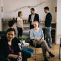 Menschen unterhalten sich sitzend und stehend in einem Buero