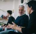 Personen sitzen in einem Büro und unterhalten sich