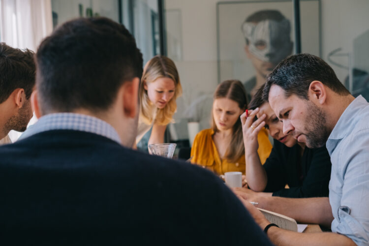 Ein Team diskutiert Lösungen an einem Tisch