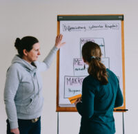 Zwei Frauen besprechen ein Ergebnis in der Systemischen Organisationsentwicklung Weiterbildung