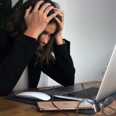 Eine Managerin sitzt gestresst vor ihrem Laptop.