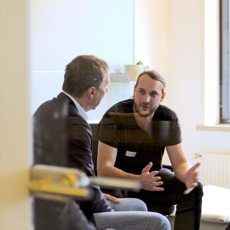 Ein Mitarbeitergespräch in einem geschützten Raum fördert die psychologische Sicherheit im Team.